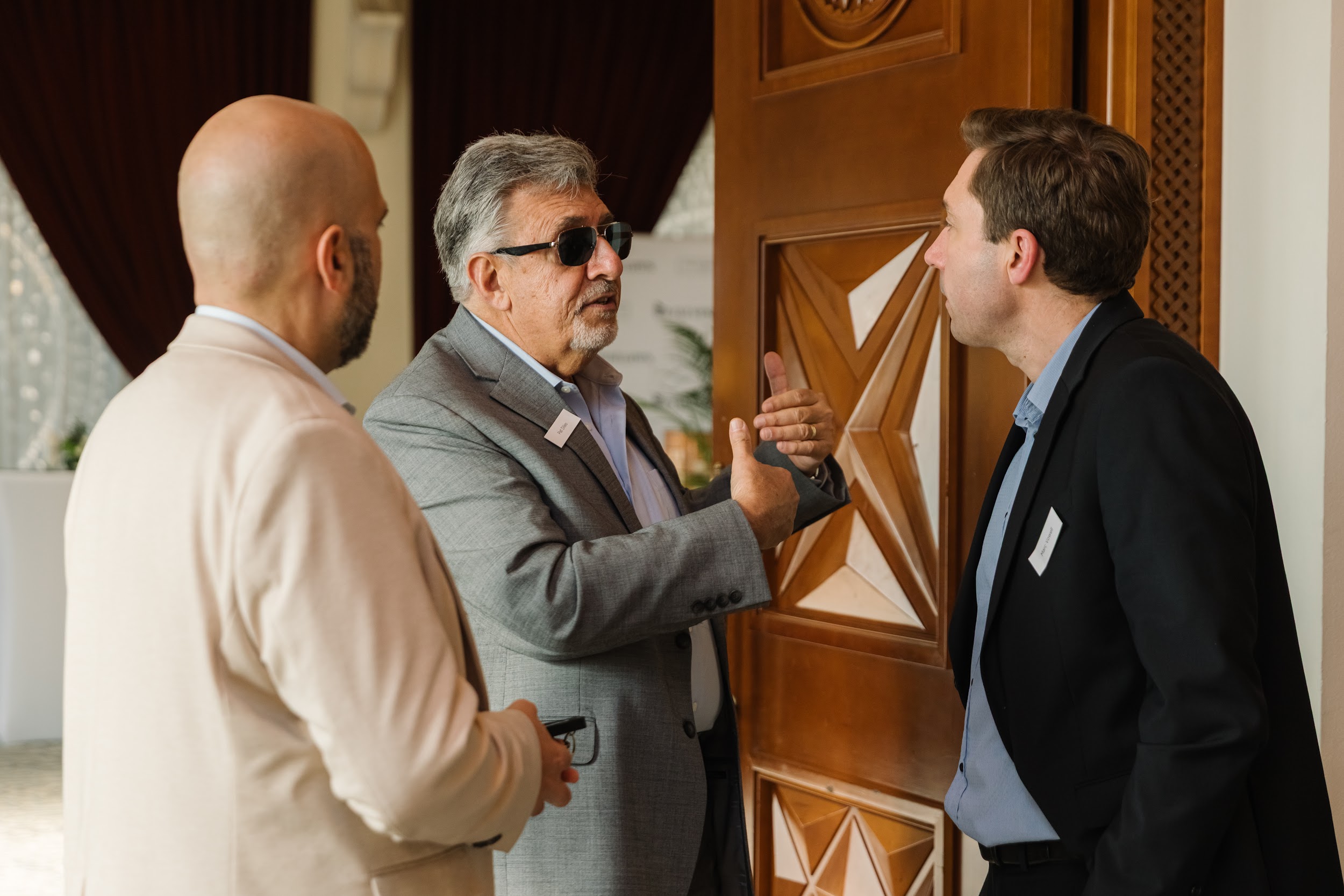 Three attendees networking at The Syndicate Global event in Dubai.