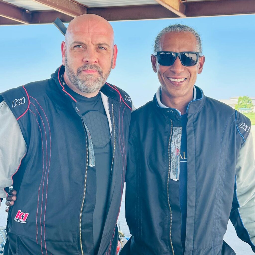 Founder of The Syndicate Global with an attendee at a private motorsport experience in Dallas, Texas, including UHNW founders, family office executives, and business leaders.